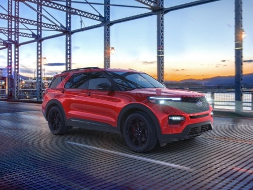 2024 Ford Explorer driving across a bridge at dusk with headlights on