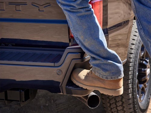 2024 Ford Super Duty close up view of man stepping on rear corner bumper